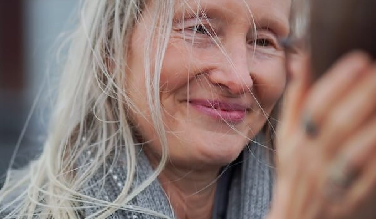 Die Bewusstseinslehrerin Sabine Weiskopf berührt sanft den Kopf einer Frau