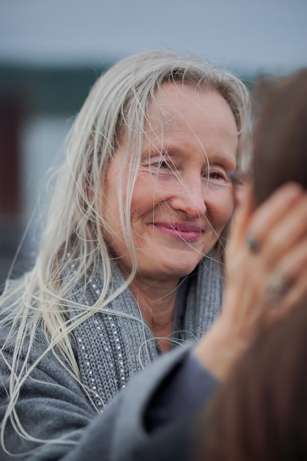 Die Bewusstseinslehrerin Sabine Weiskopf berührt sanft den Kopf einer Frau